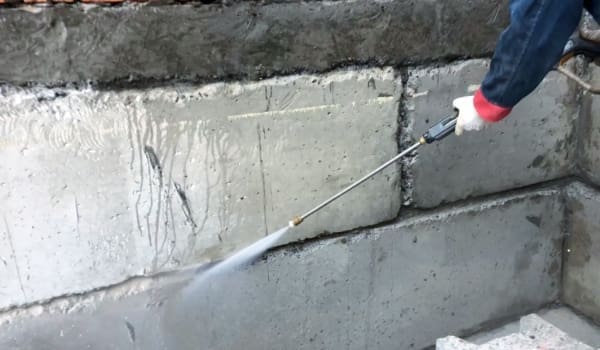 Мийка бетонної стіни під тиском для професійної гідроізоляції підвалу.