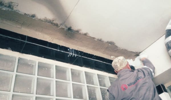 Працівник Білдкрафт накладає гідроізоляцію швів на стелю для запобігання витоку води.